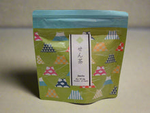 Load image into Gallery viewer, Green tea package with colorful triangle patterns on a white background