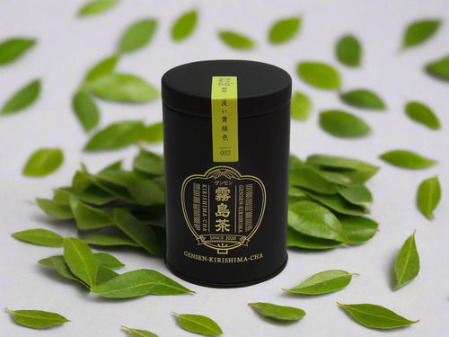 Black cylindrical tea canister with gold text and a yellow label on a white background